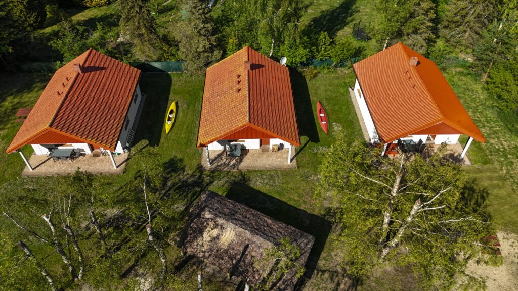 Ujęcie z góry pokazujące układ wszystkich domków na tle zieleni i drzew.